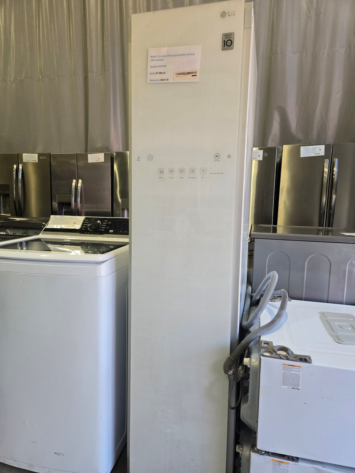 Washing machine with open door, stainless steel drum, blue trim.