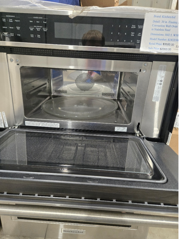 Washing machine with open door, stainless steel drum, blue trim.