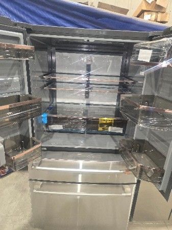 Stainless steel refrigerator with open doors, shelves visible.