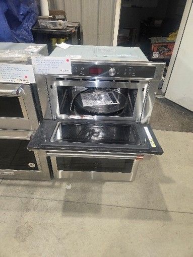 Stainless steel built-in oven with open door; interior light visible.