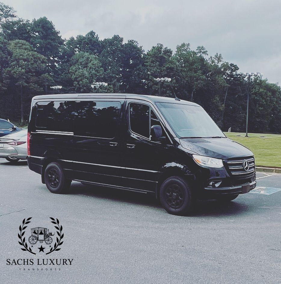 A black van from sachs luxury is parked in a parking lot