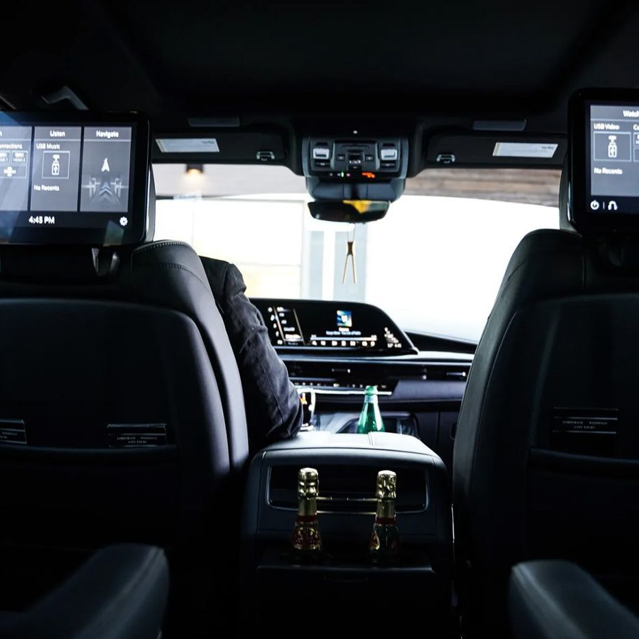 The back seat of a car with two monitors on the headrests