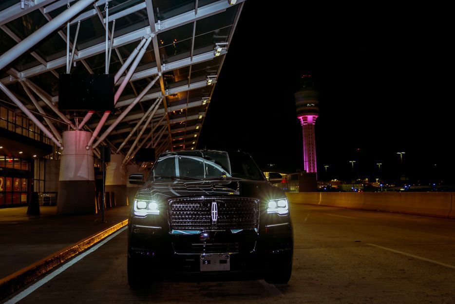 A black lincoln continental is parked in a parking lot at night.