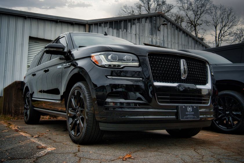 A black lincoln aviator is parked in front of a building.