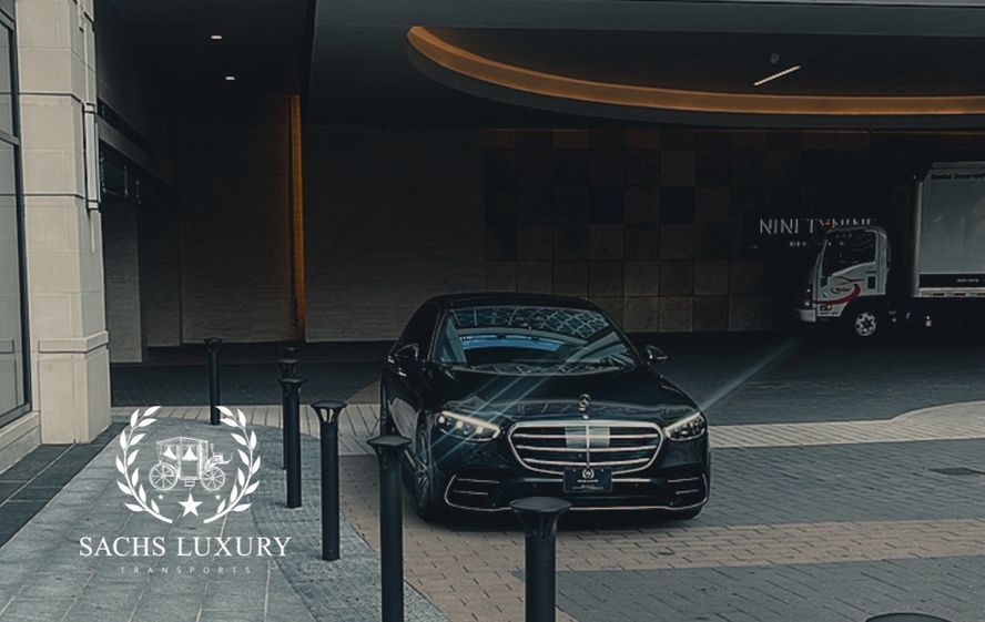 A black car is parked in front of a building.