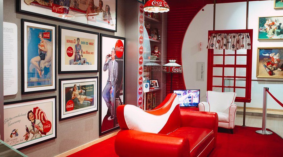 A living room with a red couch and a white chair