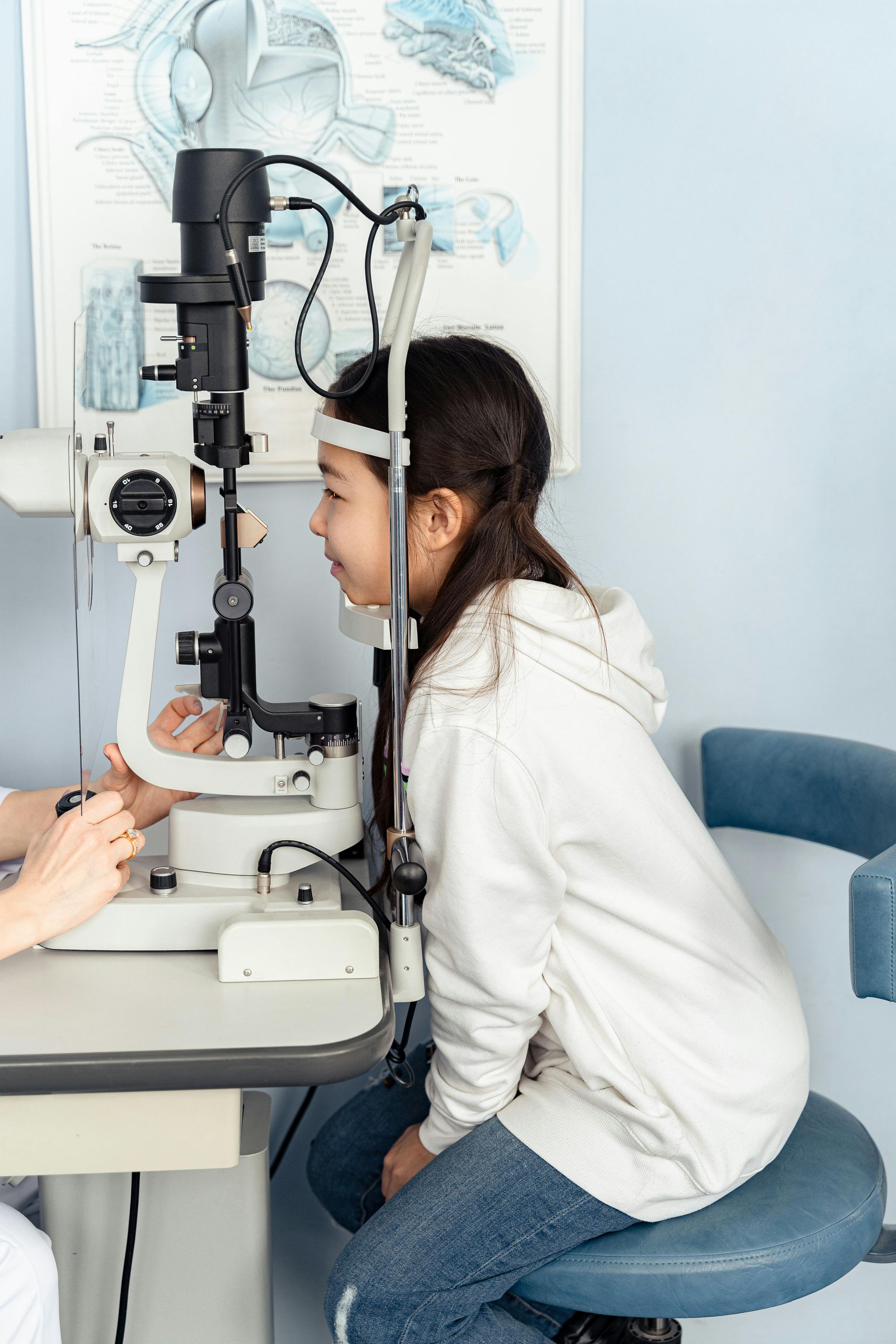 A young girl is getting her eyes examined by an ophthalmologist.