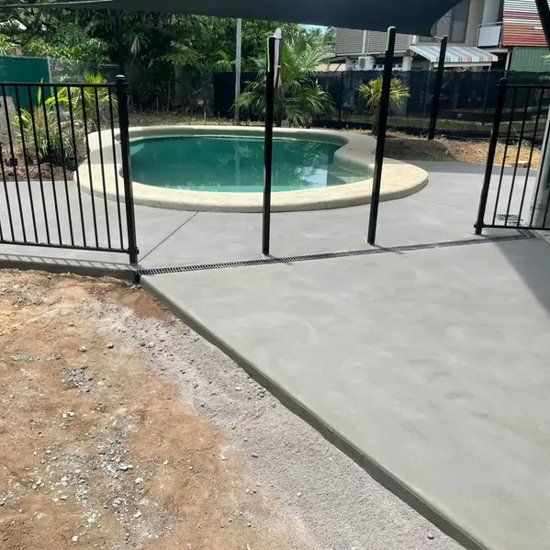 Concrete path leading to a pool with a black fence surrounding it — Mobcon Construction in Berry Springs, NT.