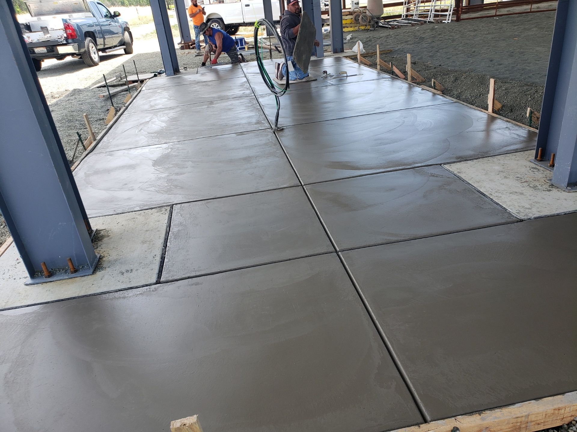 A group of people are working on a concrete floor.