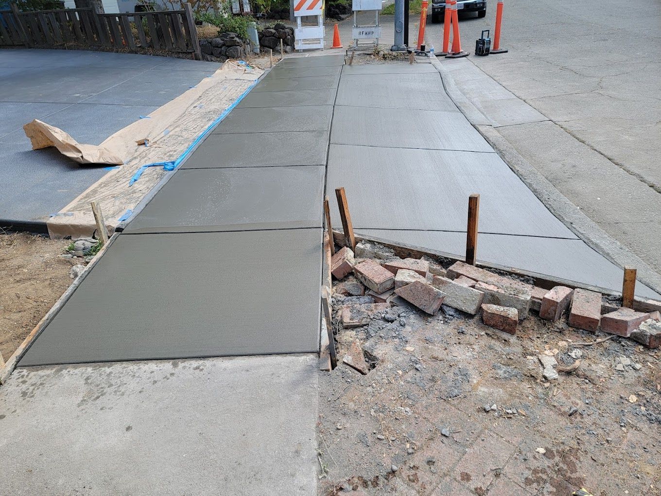 A sidewalk is being built on the side of the road.