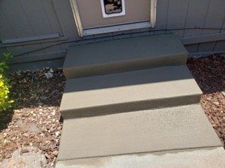 A set of concrete steps leading up to a house.