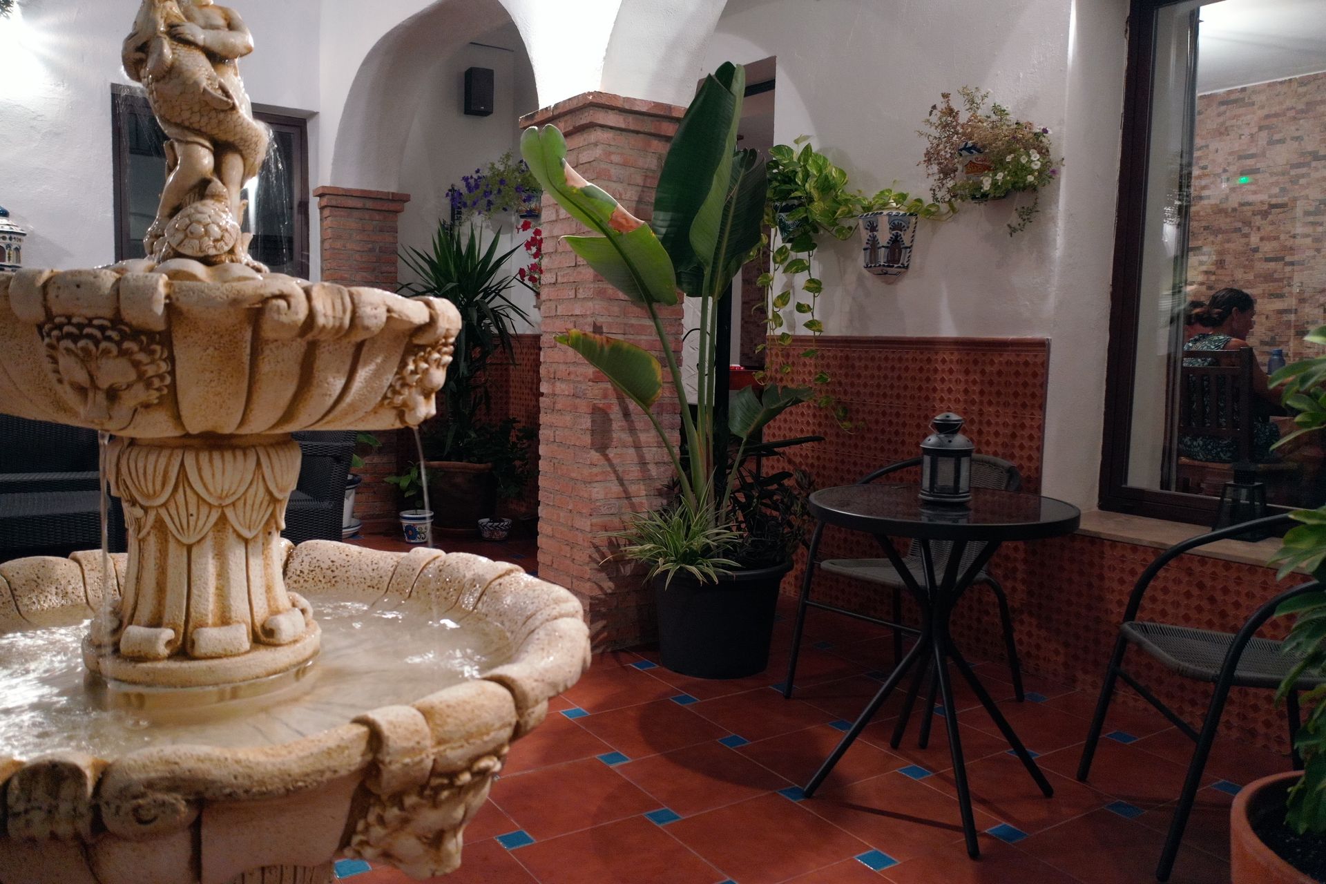 A fountain in a room with a table and chairs