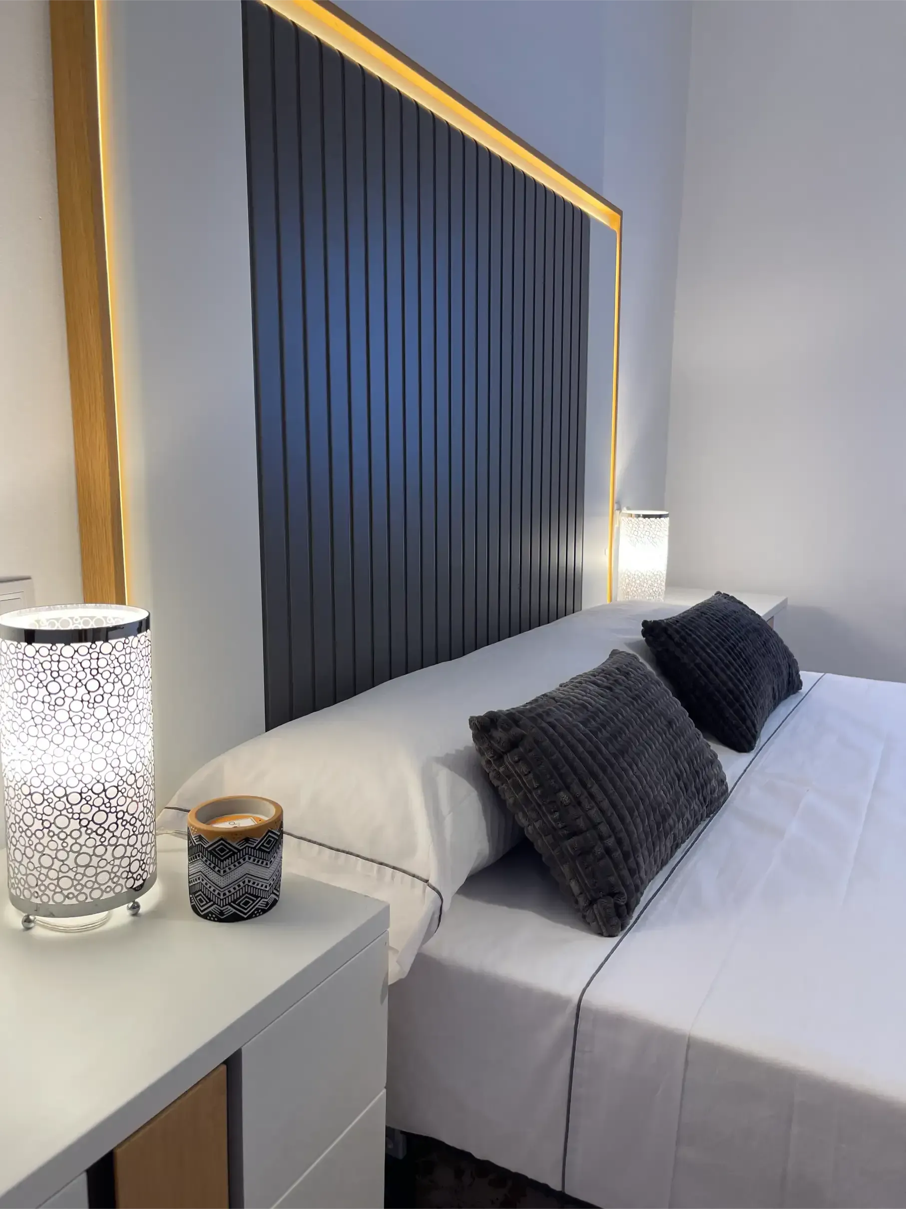 A bedroom with a bed , nightstand and lamps