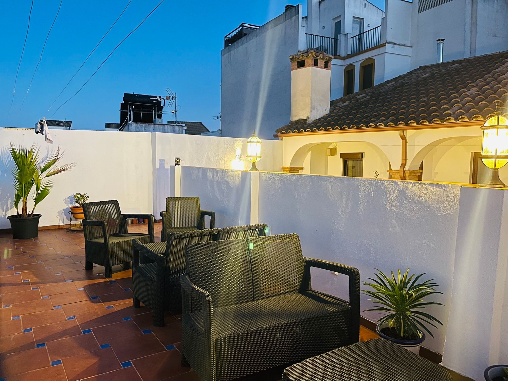 A patio with chairs and tables in front of a white building