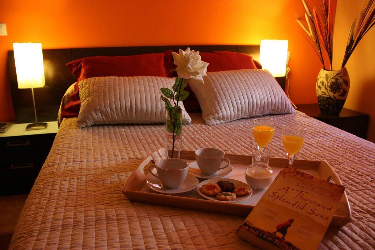 A bed with a tray of food and a book on it