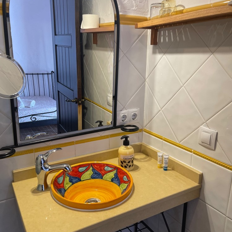 A bathroom with a round sink and a mirror