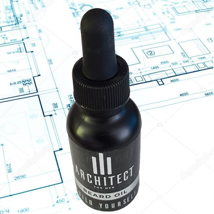 A bottle of architect beard oil sits on top of a blueprint