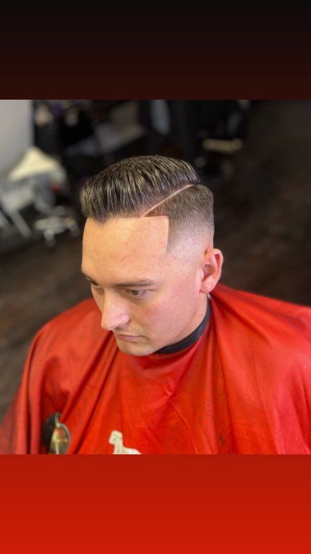 A man with a beard is getting his hair cut at a barber shop.