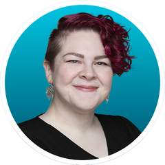 Studio portrait of a smiling person with magenta hair against a teal background
