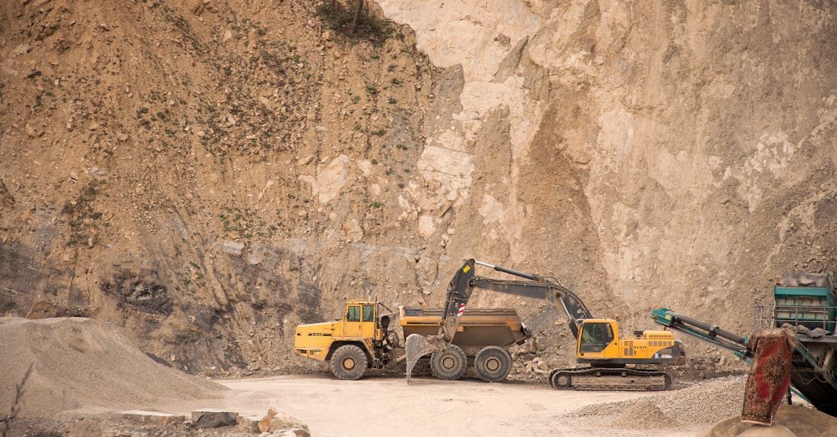 A bulldozer is loading a dump truck in a quarry.