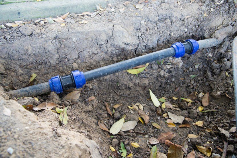 A Hose is Laying in the Dirt Next to a Pipe — TCP Plumbing in Tunglebung, NSW