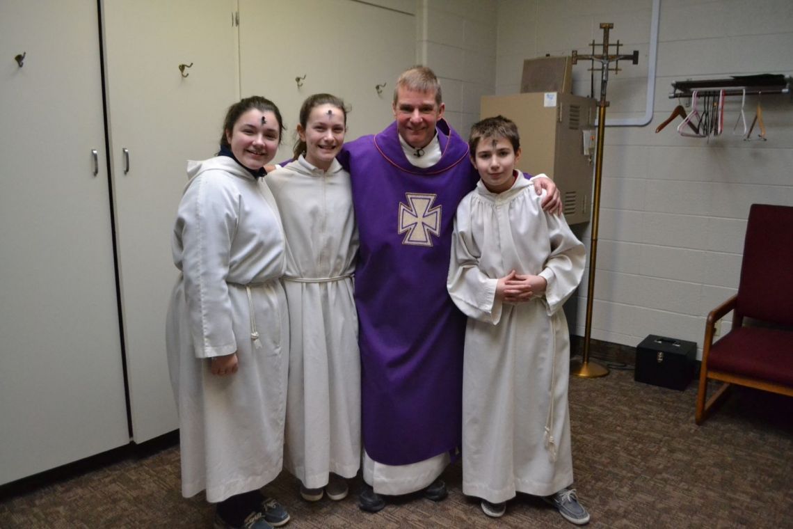 A group of people posing for a picture with a man in a purple robe