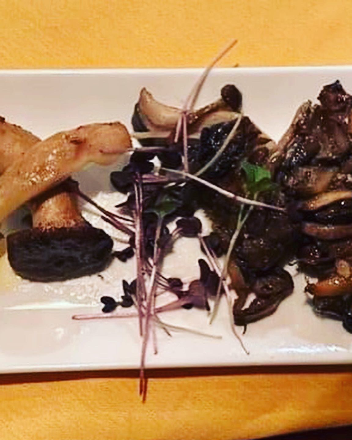 A white plate topped with mushrooms and vegetables on a table