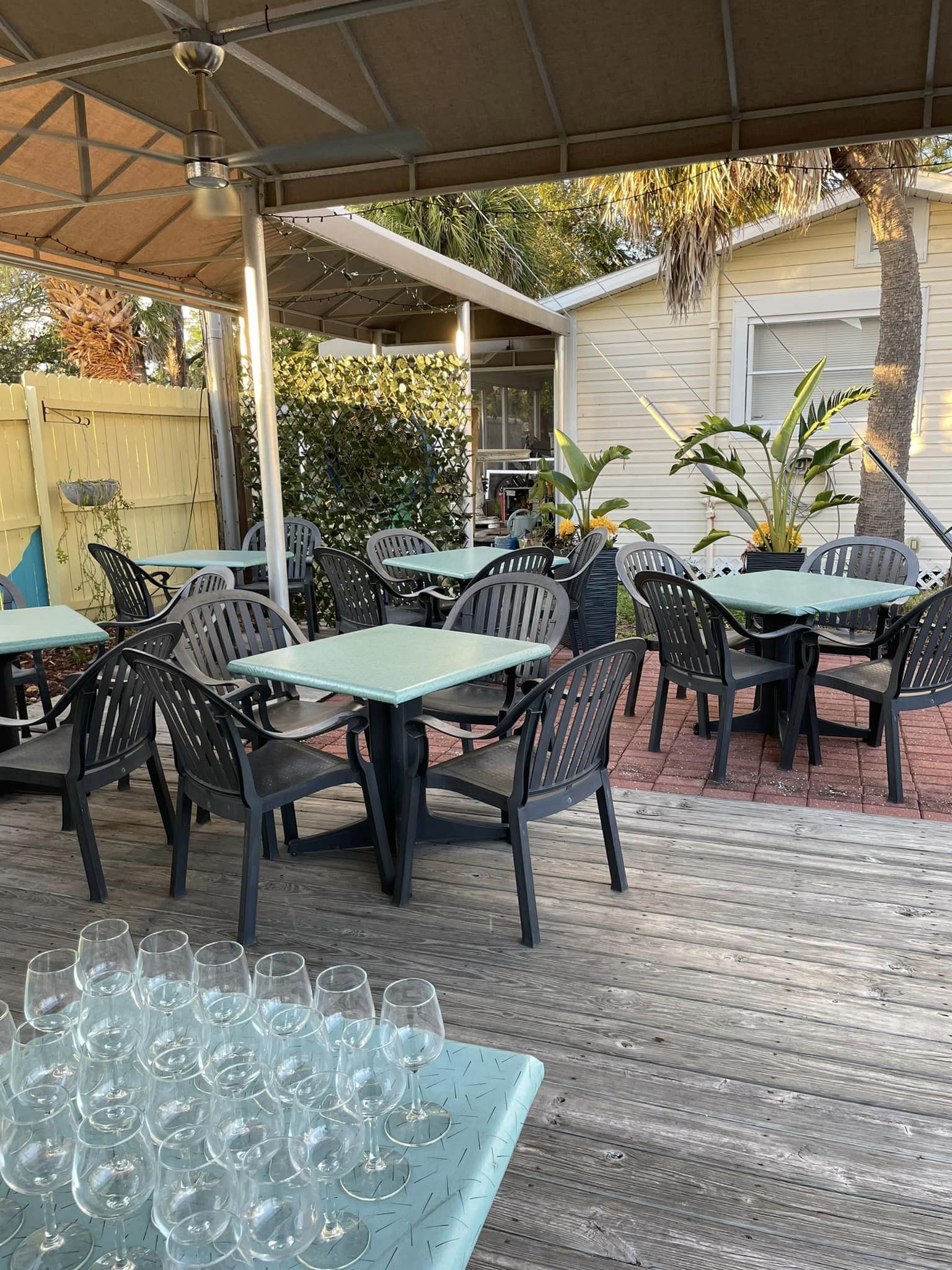 A patio with tables and chairs under a canopy.