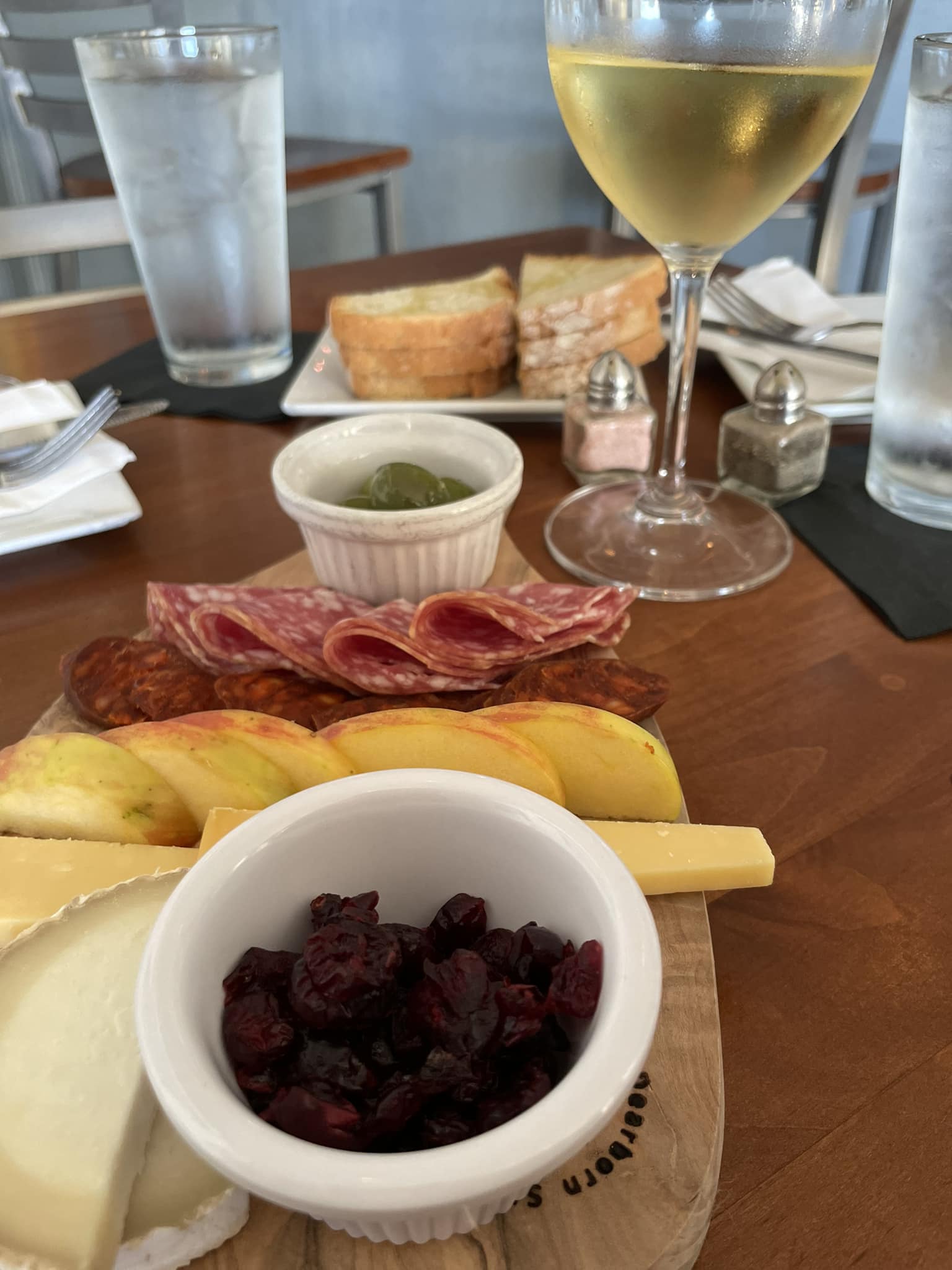 A plate of food and a glass of wine on a table.