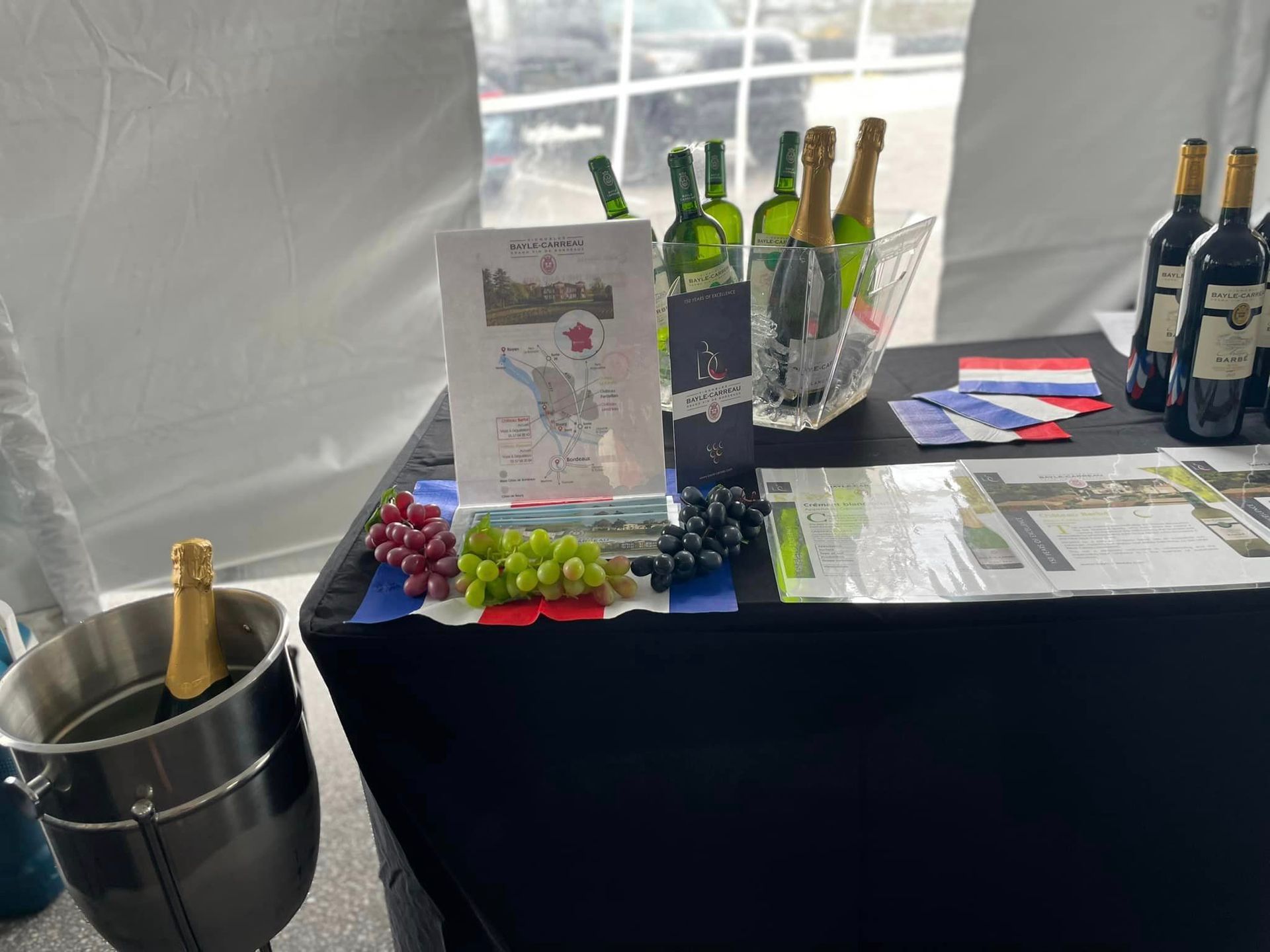 A table with bottles of wine and grapes on it.