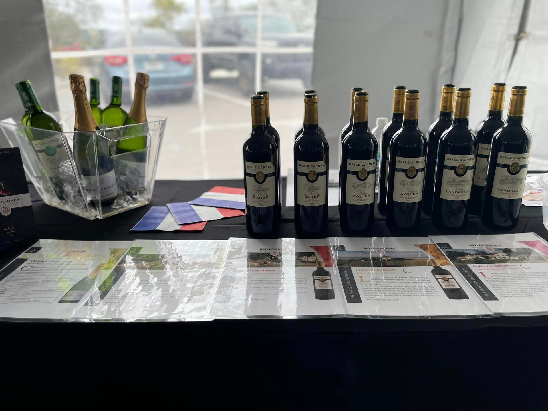 A table topped with bottles of wine and a bucket of ice.