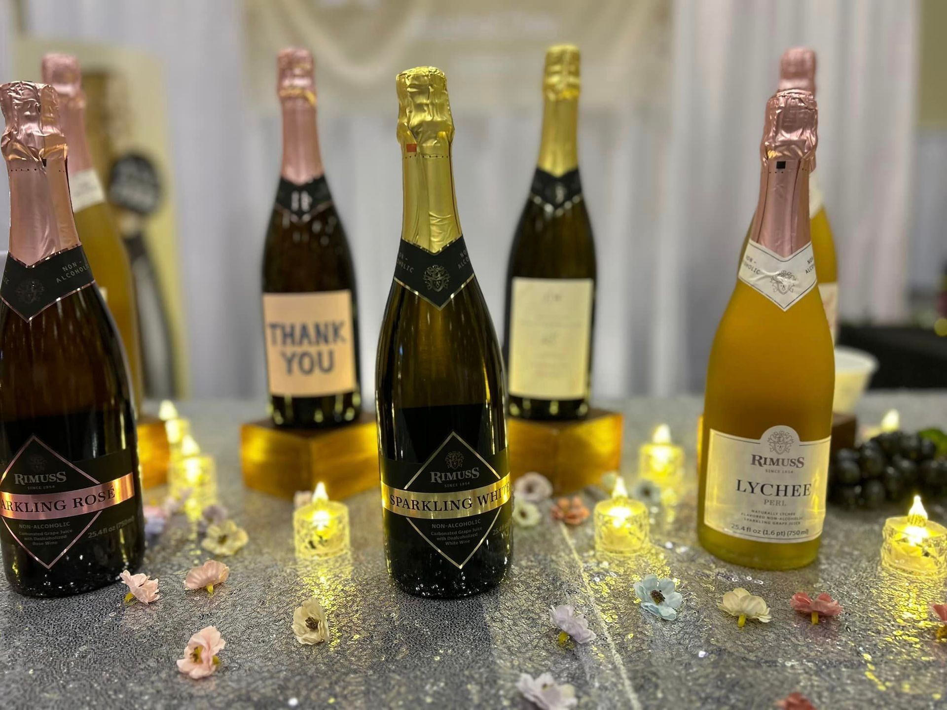 A table topped with bottles of champagne and candles.