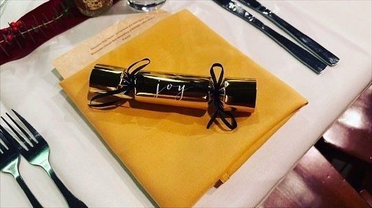 A christmas cracker is on a napkin on a table