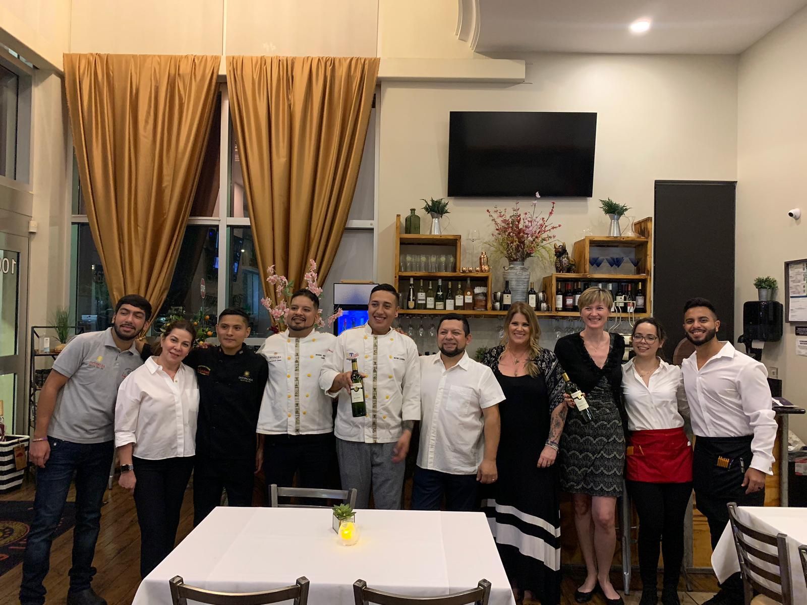 A group of people are posing for a picture in a restaurant.