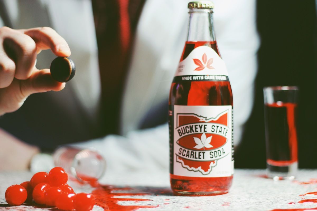 A bottle of buckeye state scarlet soda sits on a table