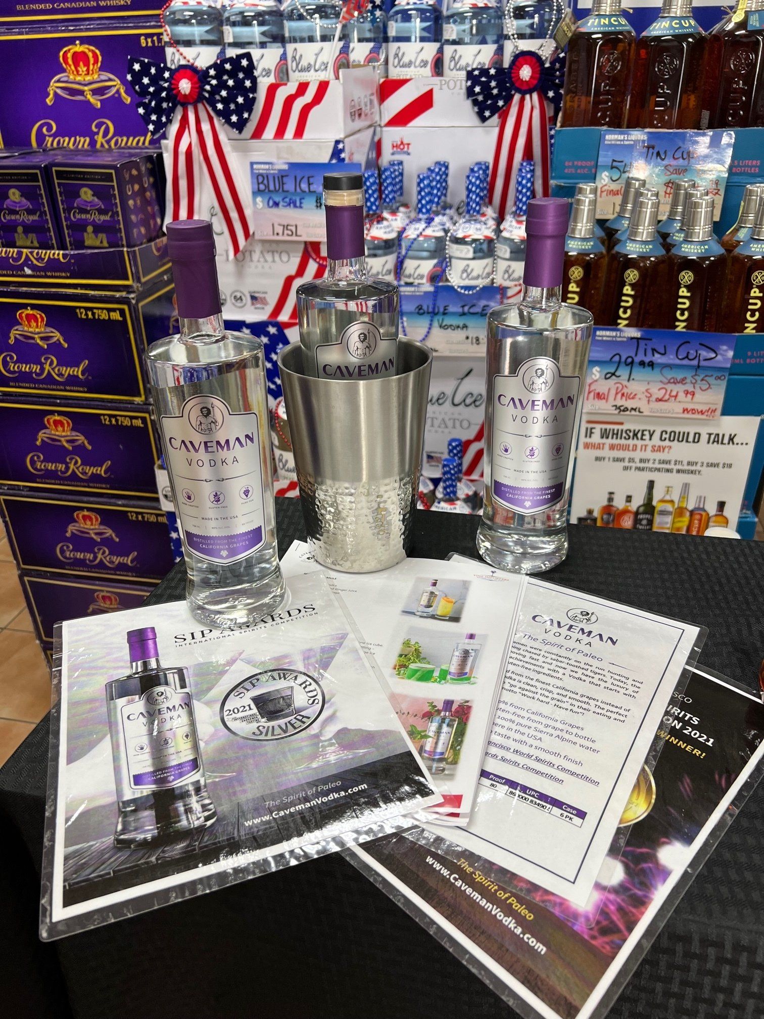 A bottle of vodka is sitting on a table next to a bucket.