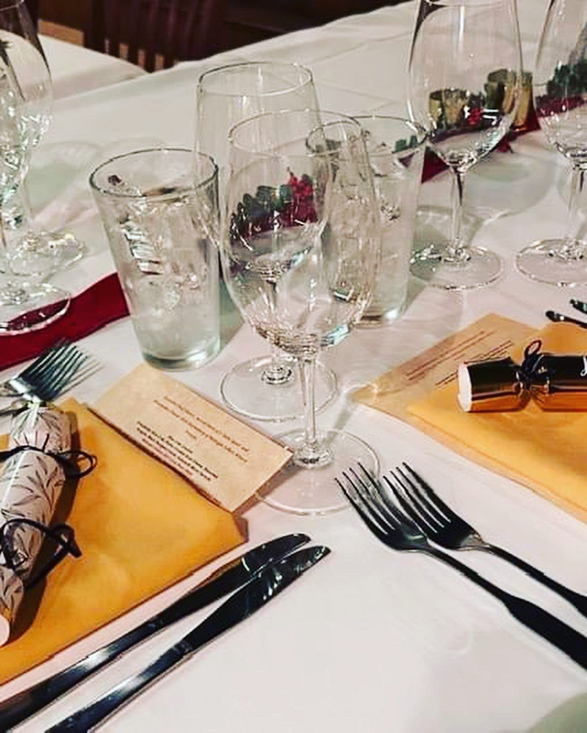 A table set for a dinner with wine glasses and silverware