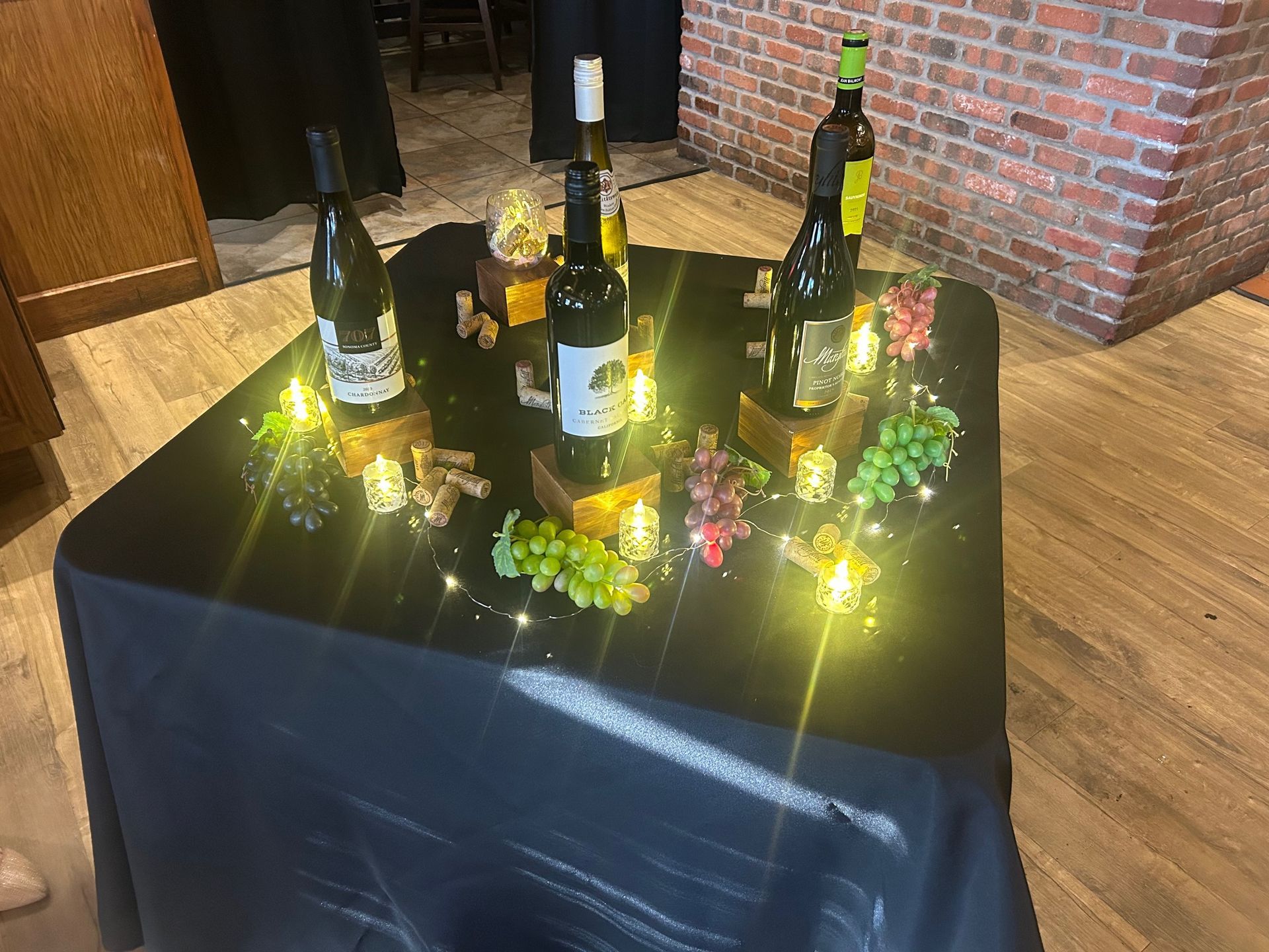 A table with bottles of wine and grapes on it.