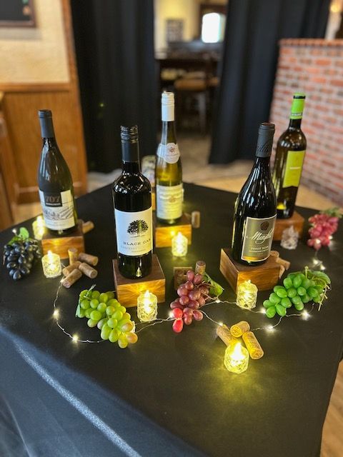 A table with bottles of wine and grapes on it