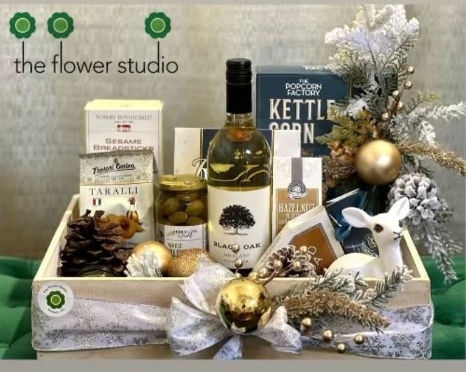 A wooden box filled with food and a bottle of wine