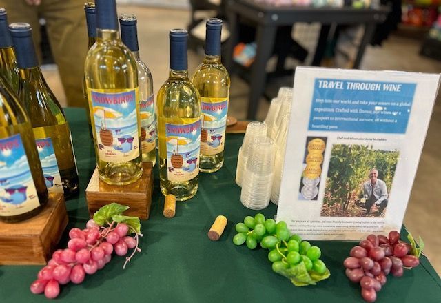 A table with bottles of wine and grapes on it