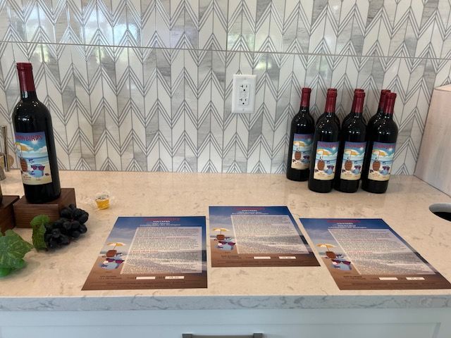A counter top with bottles of wine and papers on it.