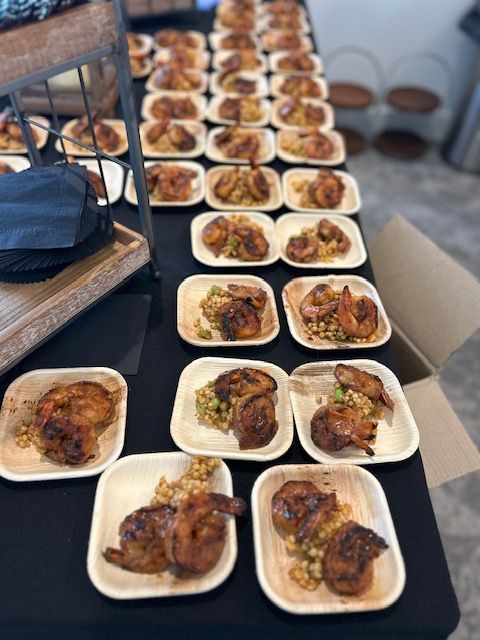 A table topped with plates of food including chicken and shrimp.