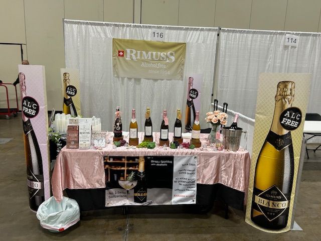 A table with bottles of wine and a sign that says rimuss