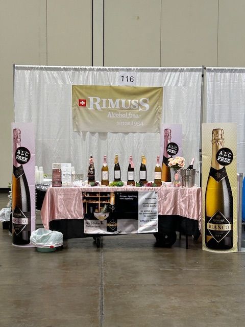 A table with bottles of wine and a sign that says rimuss