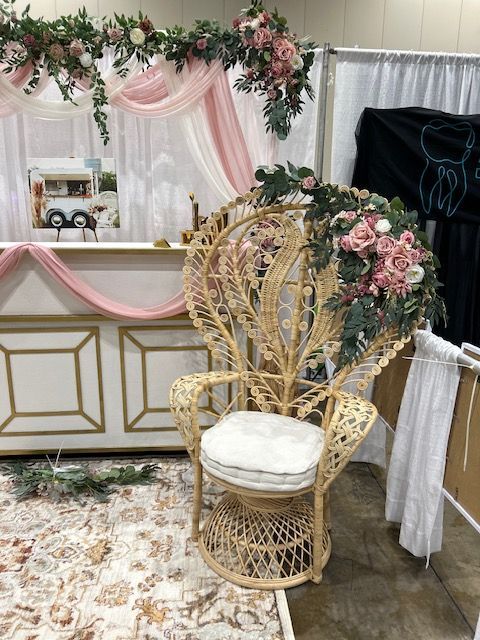 A wicker chair with flowers on it is sitting in a room.