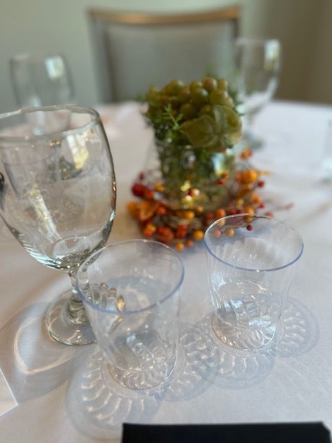 A table with wine glasses and a vase of flowers on it