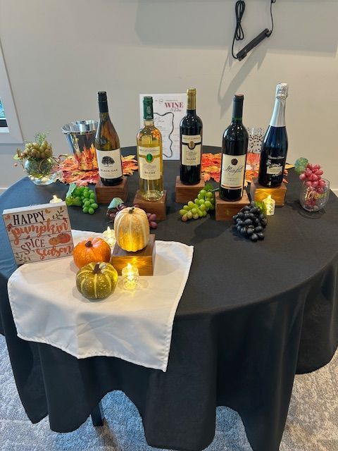 A table with bottles of wine and a sign that says happy thanksgiving