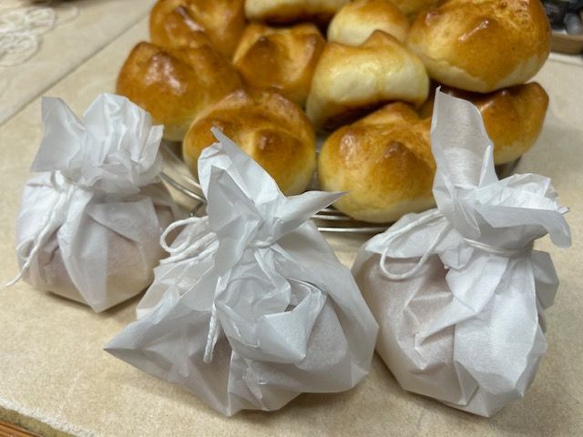 A bunch of rolls wrapped in white paper on a table
