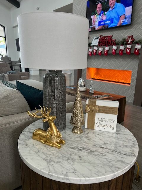 A lamp is sitting on a table in a living room with christmas decorations.